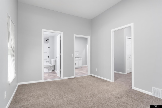 1204 S 27th St, Omaha, NE 68105 - unfurnished bedroom with multiple windows, carpet flooring, and connected bathroom