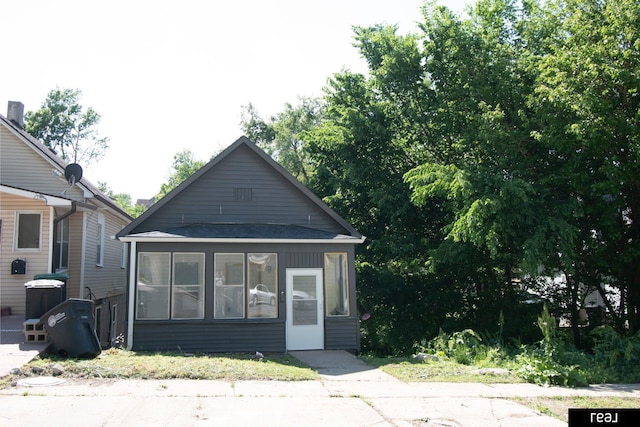 1204 S 27th St, Omaha, NE 68105 - view of front facade featuring a sunroom and a shingled roof