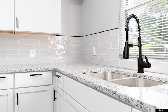 1204 S 27th St, Omaha, NE 68105 - kitchen with a sink, white cabinetry, tasteful backsplash, and light stone countertops
