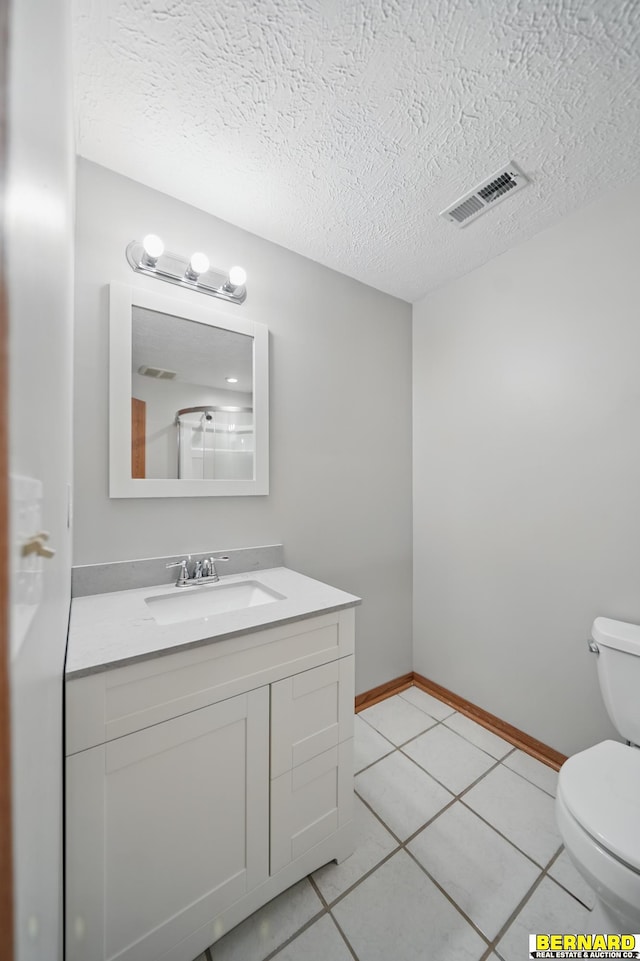 5665 I Rd, Nebraska City, NE 68410 - bathroom with toilet, vanity, tile patterned flooring, a textured ceiling, and baseboards