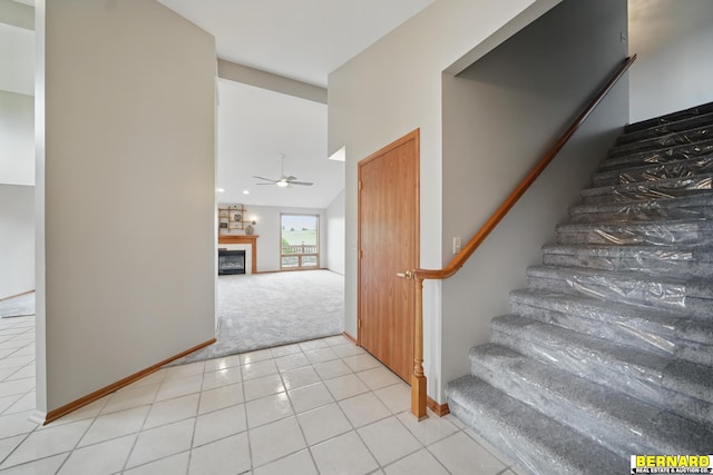 5665 I Rd, Nebraska City, NE 68410 - stairway with carpet, ceiling fan, a fireplace, tile patterned flooring, and baseboards