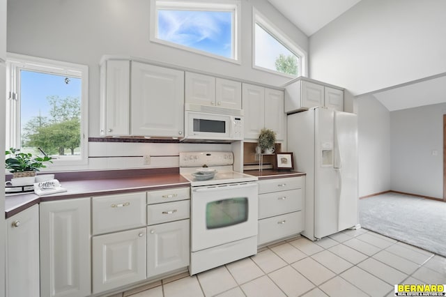 5665 I Rd, Nebraska City, NE 68410 - kitchen featuring white appliances, light colored carpet, high vaulted ceiling, white cabinets, and dark countertops