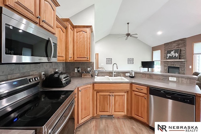 21204 Hampton Dr, Gretna, NE 68028 - kitchen with appliances with stainless steel finishes, a sink, a peninsula, a ceiling fan, and vaulted ceiling