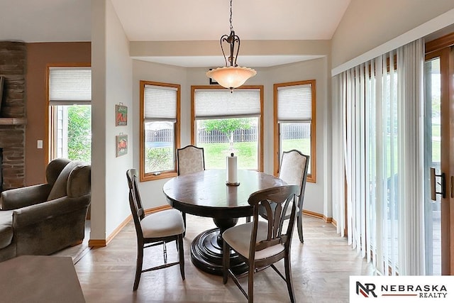 21204 Hampton Dr, Gretna, NE 68028 - dining room featuring baseboards, light wood-style flooring, lofted ceiling, and a fireplace