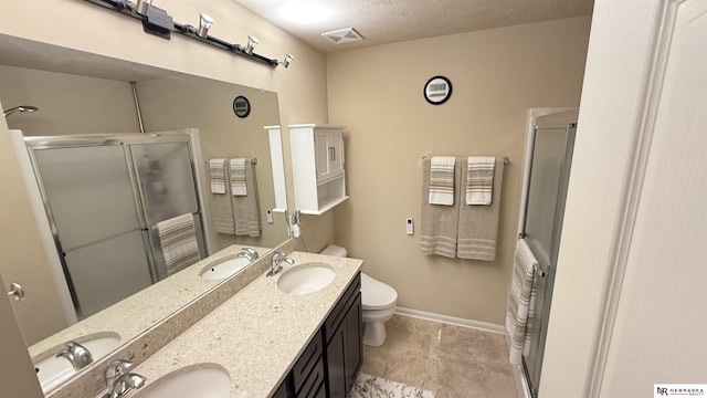 7316 N 142nd Ave, Omaha, NE 68142 - bathroom with a shower stall, double vanity, toilet, baseboards, and a textured ceiling