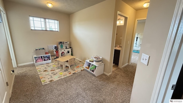 7316 N 142nd Ave, Omaha, NE 68142 - game room with carpet floors, a textured ceiling, and baseboards