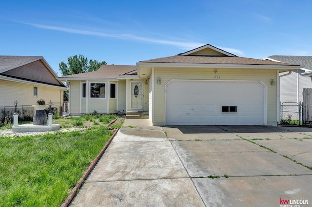 235 W Belmont Ave, Lincoln, NE 68521 - single story home featuring concrete driveway, a garage, roof with shingles, and a gate
