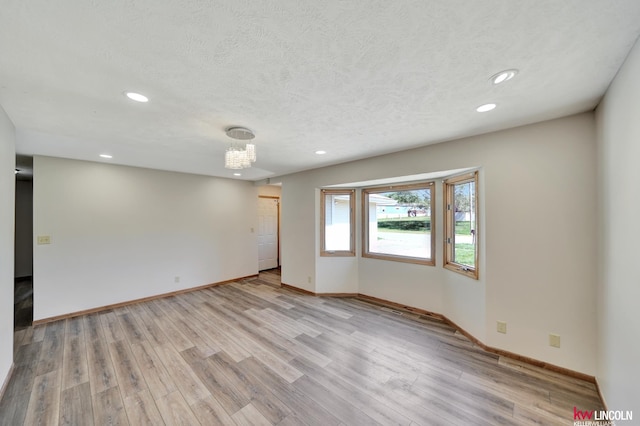 235 W Belmont Ave, Lincoln, NE 68521 - empty room with recessed lighting, light wood finished floors, baseboards, a textured ceiling, and a chandelier