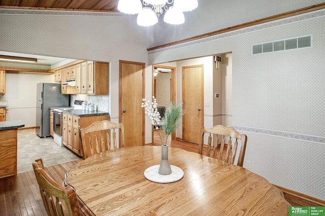 9706 N 51st St, Omaha, NE 68152 - dining area featuring wallpapered walls, crown molding, light wood-style floors, and baseboards