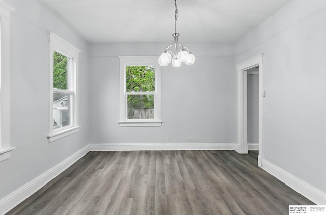 2909 N 26th St, Omaha, NE 68111 - unfurnished dining area with a chandelier, wood finished floors, and baseboards