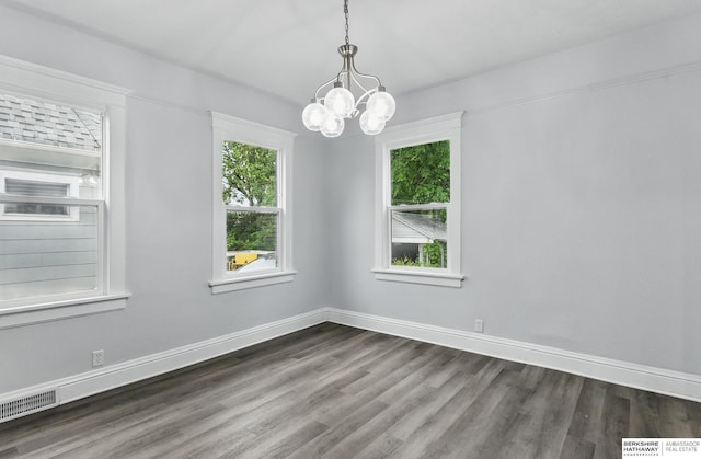 2909 N 26th St, Omaha, NE 68111 - empty room featuring dark wood finished floors, a chandelier, and baseboards