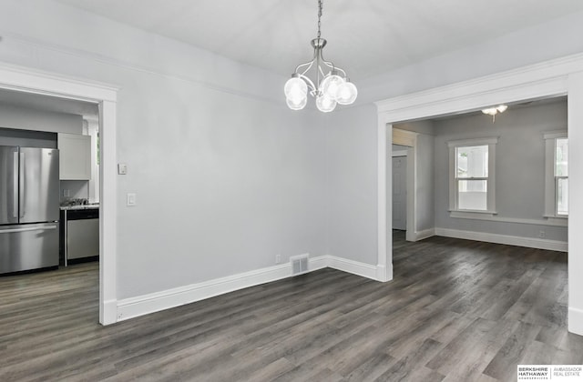 2909 N 26th St, Omaha, NE 68111 - unfurnished dining area with a chandelier, dark wood-style flooring, and baseboards