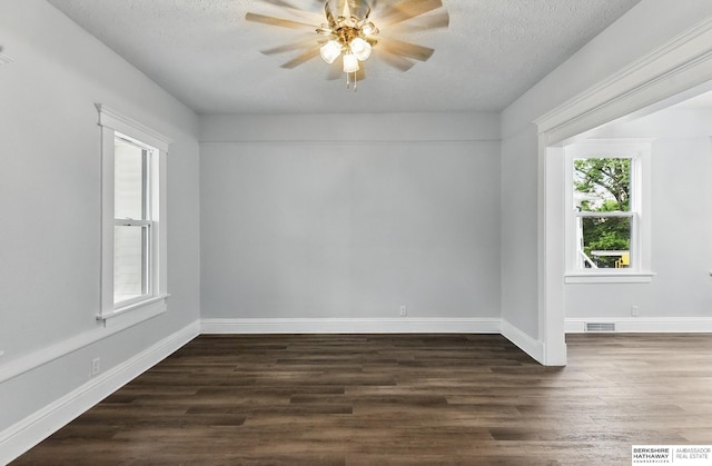 2909 N 26th St, Omaha, NE 68111 - spare room featuring dark wood finished floors, a ceiling fan, baseboards, and a textured ceiling