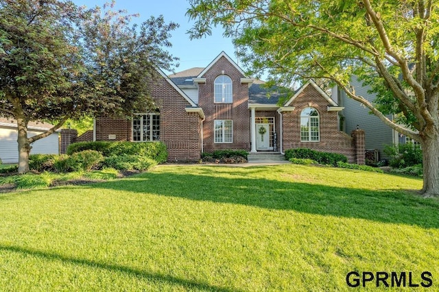 15931 Yates St, Omaha, NE 68116 - traditional-style home featuring brick siding, a front yard, and central AC unit