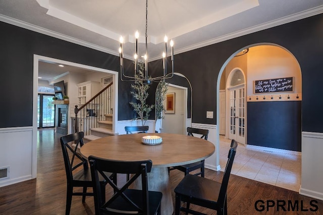 15931 Yates St, Omaha, NE 68116 - dining area featuring a chandelier, stairs, wood finished floors, a wainscoted wall, and a tray ceiling