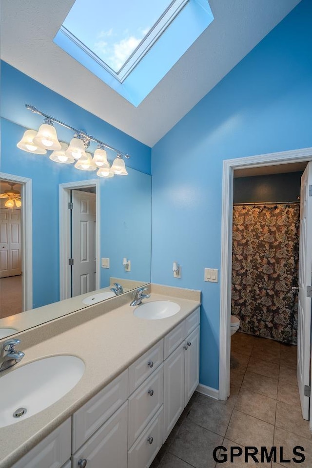 15931 Yates St, Omaha, NE 68116 - full bath with a skylight, double vanity, vaulted ceiling, toilet, and tile patterned flooring
