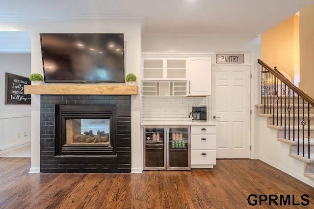 15931 Yates St, Omaha, NE 68116 - bar featuring wine cooler, stairs, dark wood finished floors, ornamental molding, and baseboards