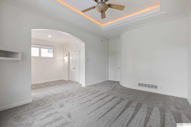 14906 Hanover St, Bennington, NE 68007 - carpeted spare room featuring arched walkways, a tray ceiling, crown molding, ceiling fan, and baseboards