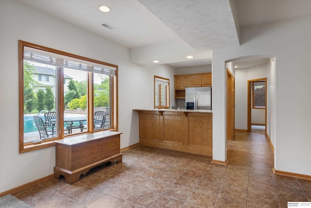 14906 Hanover St, Bennington, NE 68007 - kitchen featuring stainless steel refrigerator with ice dispenser, arched walkways, baseboards, and recessed lighting