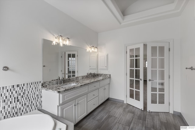 14906 Hanover St, Bennington, NE 68007 - full bath with french doors, double vanity, a tub, and baseboards