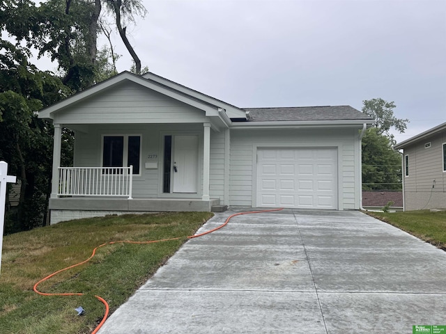2273 N 38th Ave, Omaha, NE 68111 - view of front of house with covered porch, a garage, concrete driveway, a front yard, and roof with shingles