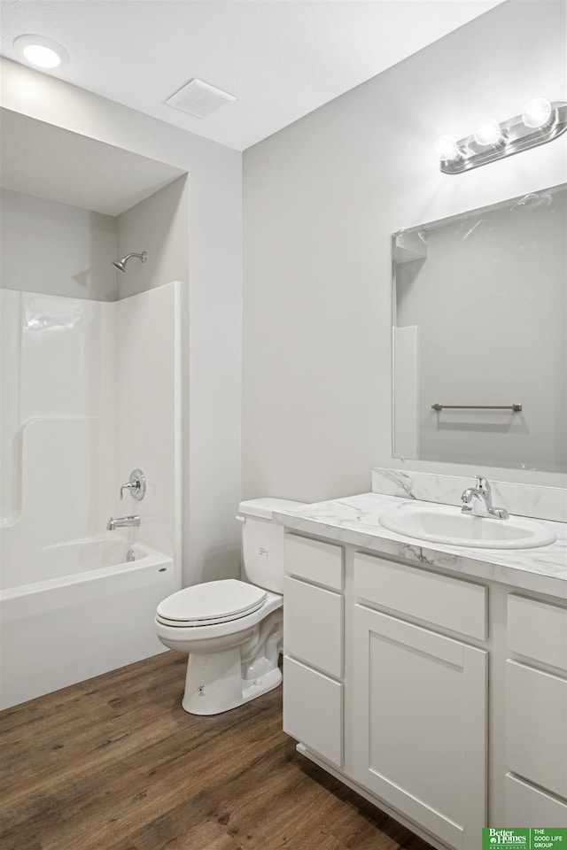 2273 N 38th Ave, Omaha, NE 68111 - full bathroom featuring vanity, toilet, wood finished floors, and bathing tub / shower combination