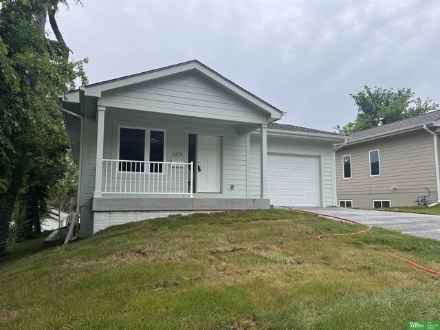 2273 N 38th Ave, Omaha, NE 68111 - view of front facade featuring covered porch, a garage, concrete driveway, and a front lawn