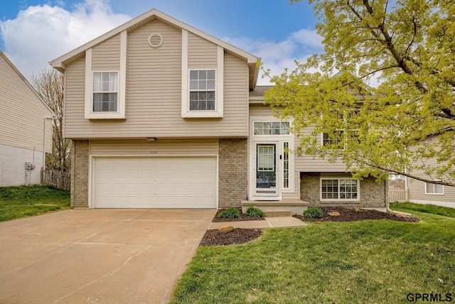 15614 Redwood St, Omaha, NE 68136 - view of front of home featuring a garage, a front yard, concrete driveway, and brick siding