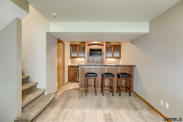 15614 Redwood St, Omaha, NE 68136 - indoor bar with decorative backsplash, light wood finished floors, stairs, and baseboards