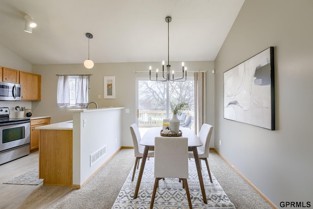 15614 Redwood St, Omaha, NE 68136 - dining area featuring a chandelier, lofted ceiling, baseboards, and light colored carpet