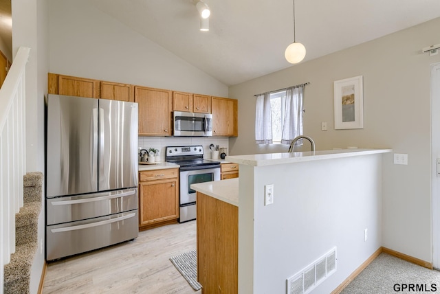 15614 Redwood St, Omaha, NE 68136 - kitchen with stainless steel appliances, light countertops, vaulted ceiling, tasteful backsplash, and decorative light fixtures