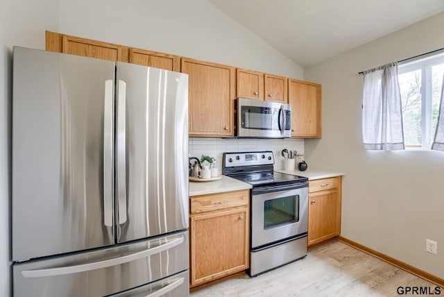 15614 Redwood St, Omaha, NE 68136 - kitchen with appliances with stainless steel finishes, vaulted ceiling, tasteful backsplash, light wood finished floors, and light countertops