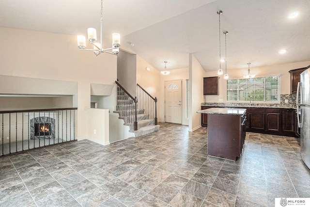 7423 N 139th Ave, Omaha, NE 68142 - kitchen with open floor plan, a center island, a chandelier, dark brown cabinets, and vaulted ceiling