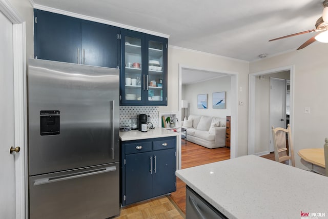 3920 Randolph St, Lincoln, NE 68510 - kitchen with stainless steel appliances, blue cabinetry, a ceiling fan, glass insert cabinets, and ornamental molding