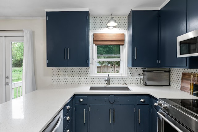 3920 Randolph St, Lincoln, NE 68510 - kitchen featuring a sink, stainless steel appliances, blue cabinets, light countertops, and crown molding