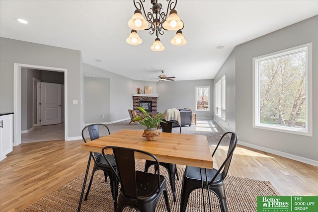 16831 Chandler St, Omaha, NE 68136 - dining space featuring a brick fireplace, light wood-style flooring, baseboards, and a chandelier
