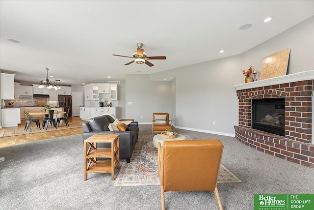 16831 Chandler St, Omaha, NE 68136 - living area featuring a fireplace, ceiling fan, light carpet, baseboards, and recessed lighting