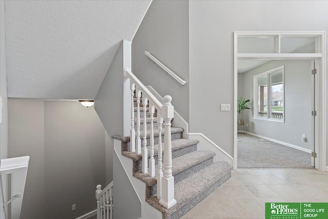 16831 Chandler St, Omaha, NE 68136 - stairs with carpet, baseboards, tile patterned floors, and a textured ceiling