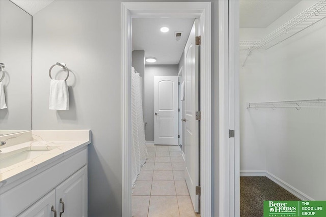 16831 Chandler St, Omaha, NE 68136 - full bath featuring vanity, tile patterned flooring, a walk in closet, and baseboards