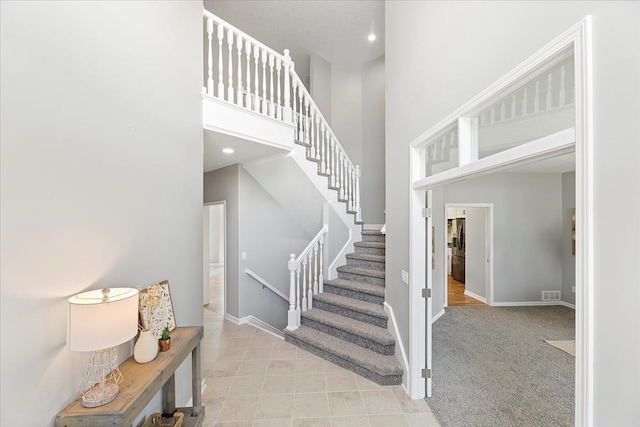 16831 Chandler St, Omaha, NE 68136 - stairs with a towering ceiling, baseboards, tile patterned floors, recessed lighting, and carpet