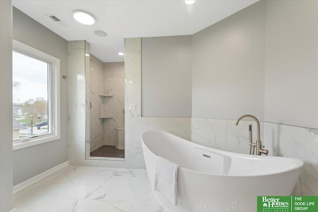 16831 Chandler St, Omaha, NE 68136 - full bathroom featuring tile walls, marble look tiles, a marble finish shower, a freestanding tub, and wainscoting
