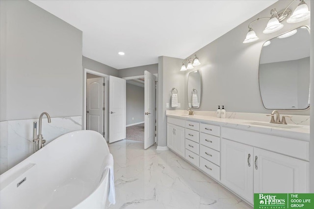 16831 Chandler St, Omaha, NE 68136 - bathroom featuring marble look tiles, double vanity, a freestanding tub, recessed lighting, and a wainscoted wall