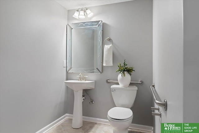 16831 Chandler St, Omaha, NE 68136 - bathroom with toilet, tile patterned flooring, a chandelier, and baseboards