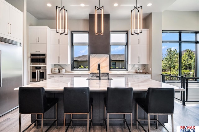 1520 S 218th St, Elkhorn, NE 68022 - kitchen featuring a sink, stainless steel appliances, an island with sink, tasteful backsplash, and hanging light fixtures