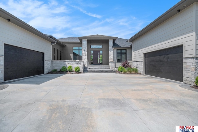 1520 S 218th St, Elkhorn, NE 68022 - view of exterior entry featuring driveway, stone siding, and an attached garage