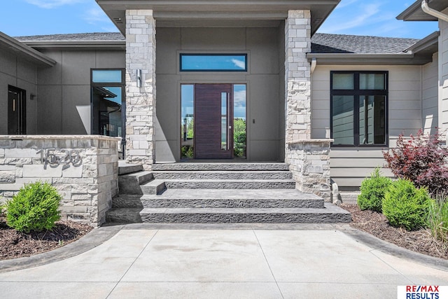 1520 S 218th St, Elkhorn, NE 68022 - view of exterior entry featuring stone siding and a shingled roof