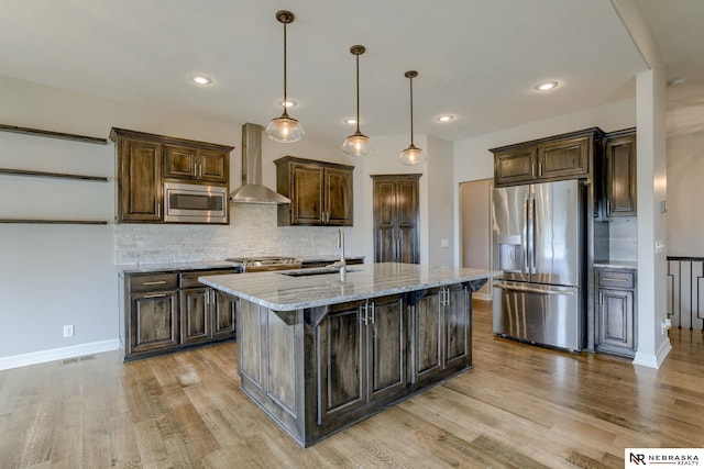 11051 Edgewater Dr, Papillion, NE 68046 - kitchen with stainless steel appliances, wall chimney exhaust hood, a sink, light wood-style floors, and tasteful backsplash