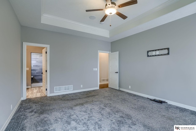 11051 Edgewater Dr, Papillion, NE 68046 - unfurnished bedroom with crown molding, a tray ceiling, carpet, baseboards, and connected bathroom