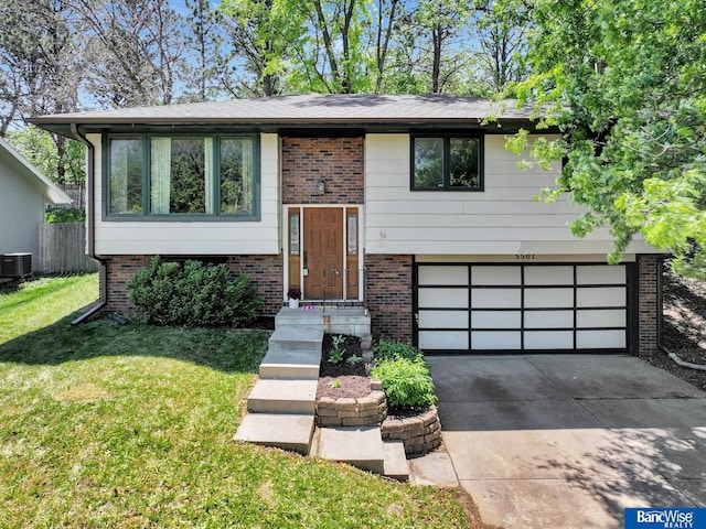 5501 London Rd, Lincoln, NE 68516 - raised ranch with driveway, brick siding, an attached garage, and cooling unit