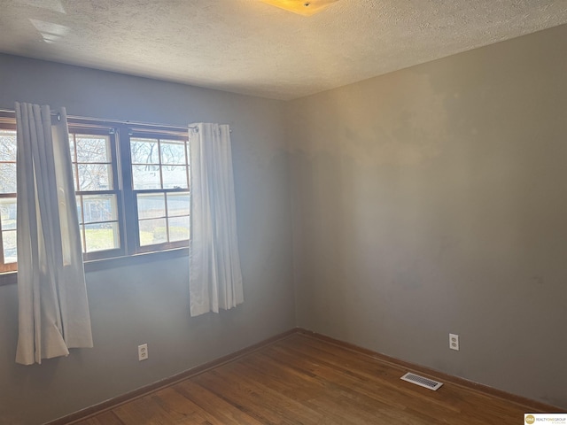 7624 Nebraska Ave, Omaha, NE 68134 - spare room featuring dark wood-type flooring, a textured ceiling, and baseboards